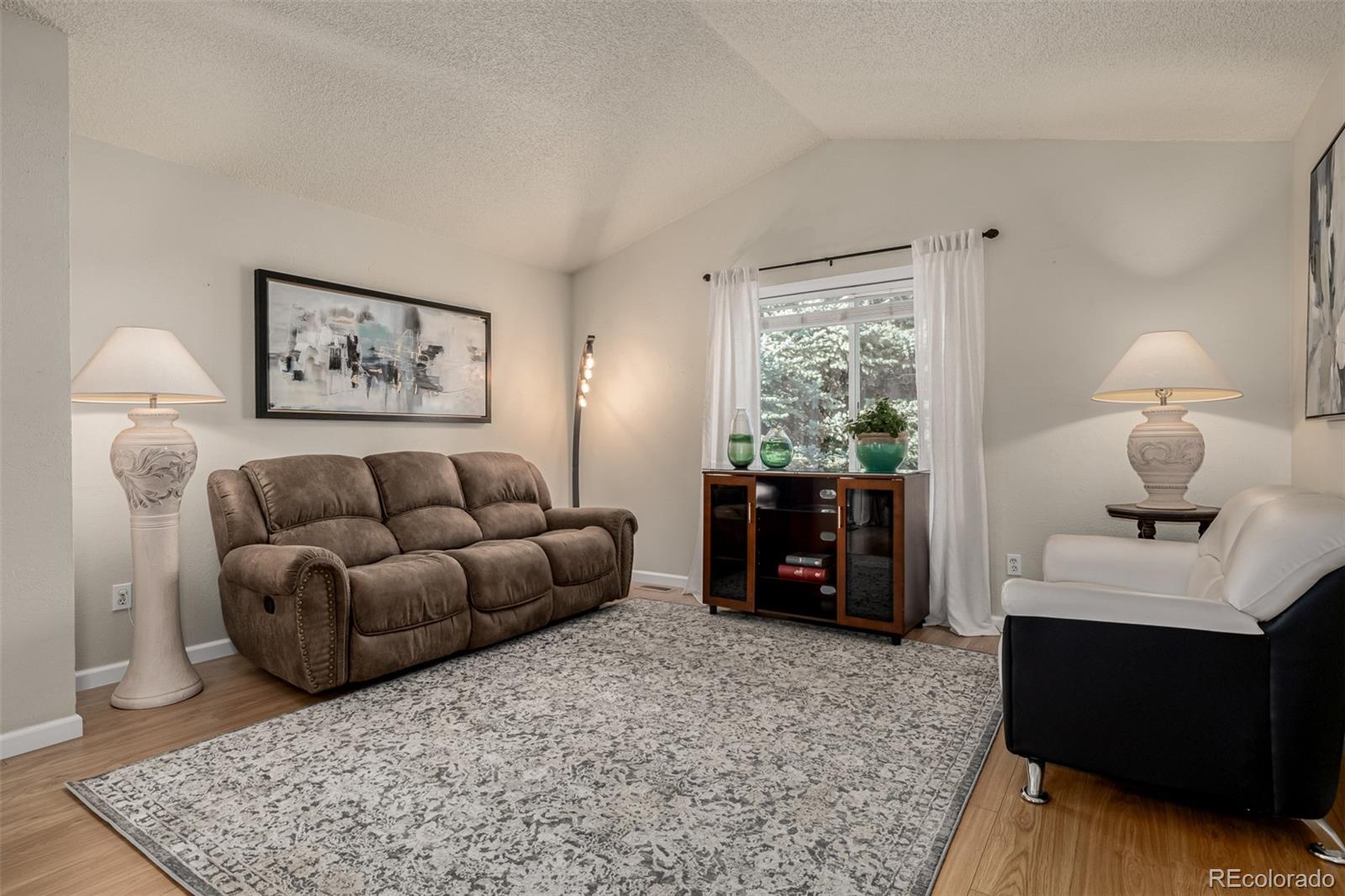 7624 Gray Way Arvada, CO 80003 - Photo 7 of 39 a living room with furniture and a fireplace