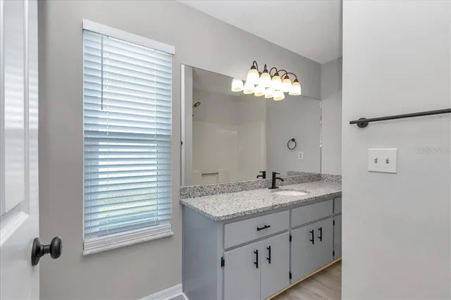 a bathroom with a granite countertop sink and a mirror