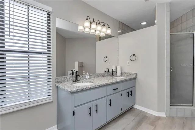a bathroom with a granite countertop sink and a mirror
