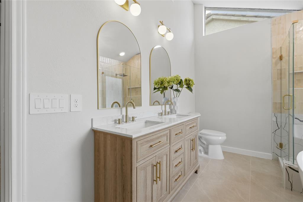 17118 Planters Row Addison, TX 75001 - Photo 17 of 18 Double vanity with wood-finish cabinetry, gold-tone hardware, and white countertop