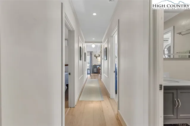 a view of a hallway with wooden floor and a living room