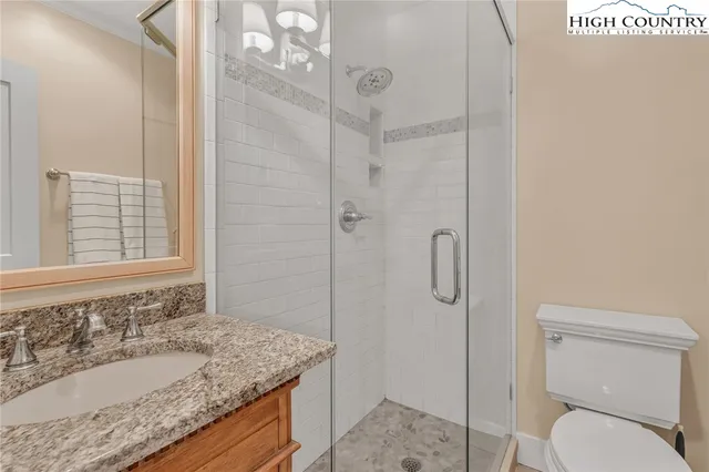 a bathroom with a granite countertop sink toilet and shower