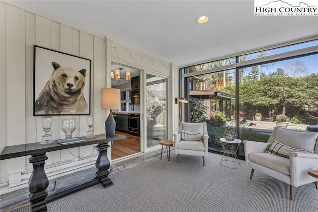 a living room with furniture a flat screen tv and a window