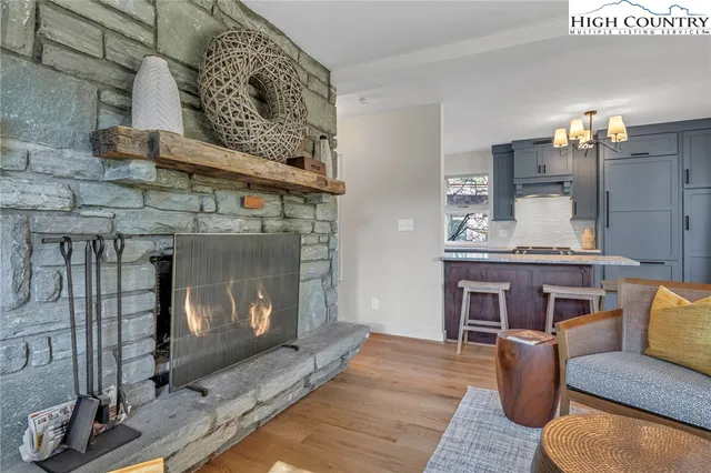 a living room with furniture a fireplace and kitchen view