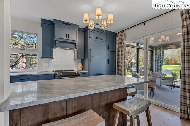 a dining hall with stainless steel appliances granite countertop a stove refrigerator and dining table with wooden floor