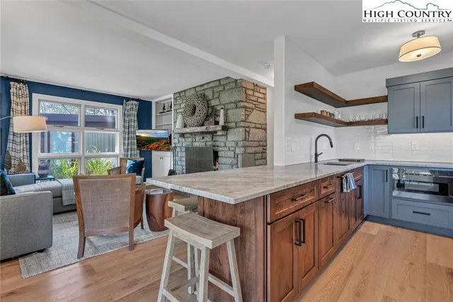 a kitchen with a table chairs and wooden floor