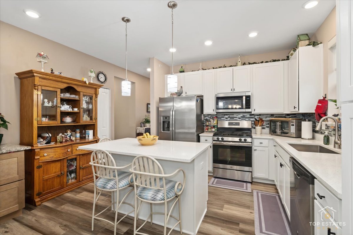 2010 Azure Lane Algonquin, IL 60102 - Photo 13 of 41 a kitchen with stainless steel appliances kitchen island granite countertop a refrigerator a stove top oven a sink dishwasher and white cabinets with wooden floor