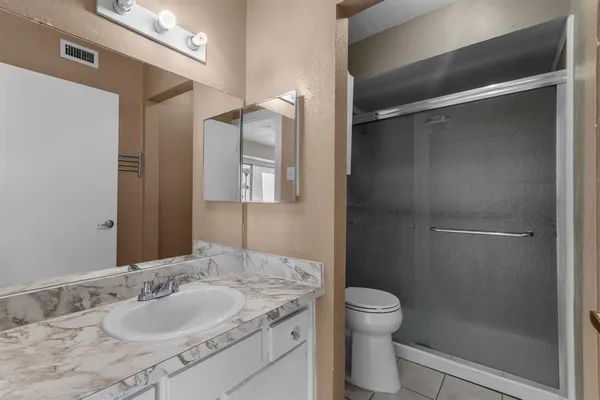 a bathroom with a granite countertop sink toilet and shower