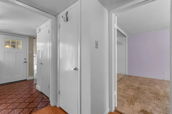 a view of a hallway with wooden floor and closet area