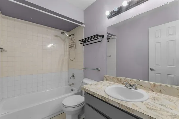 a bathroom with a granite countertop sink toilet mirror and shower