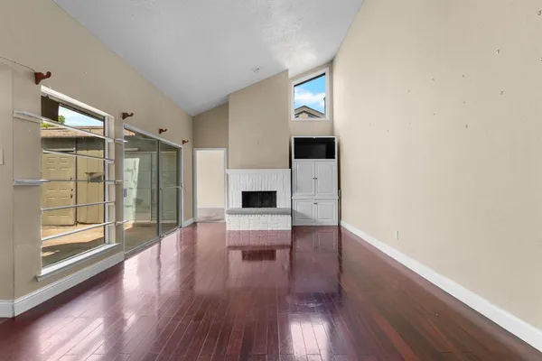 a view of a livingroom with wooden floor a fireplace and window