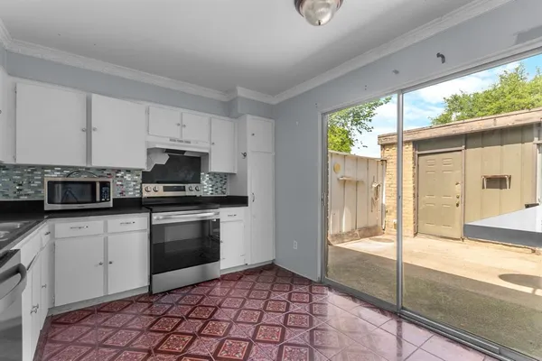 a kitchen with stainless steel appliances granite countertop a stove a sink and a microwave