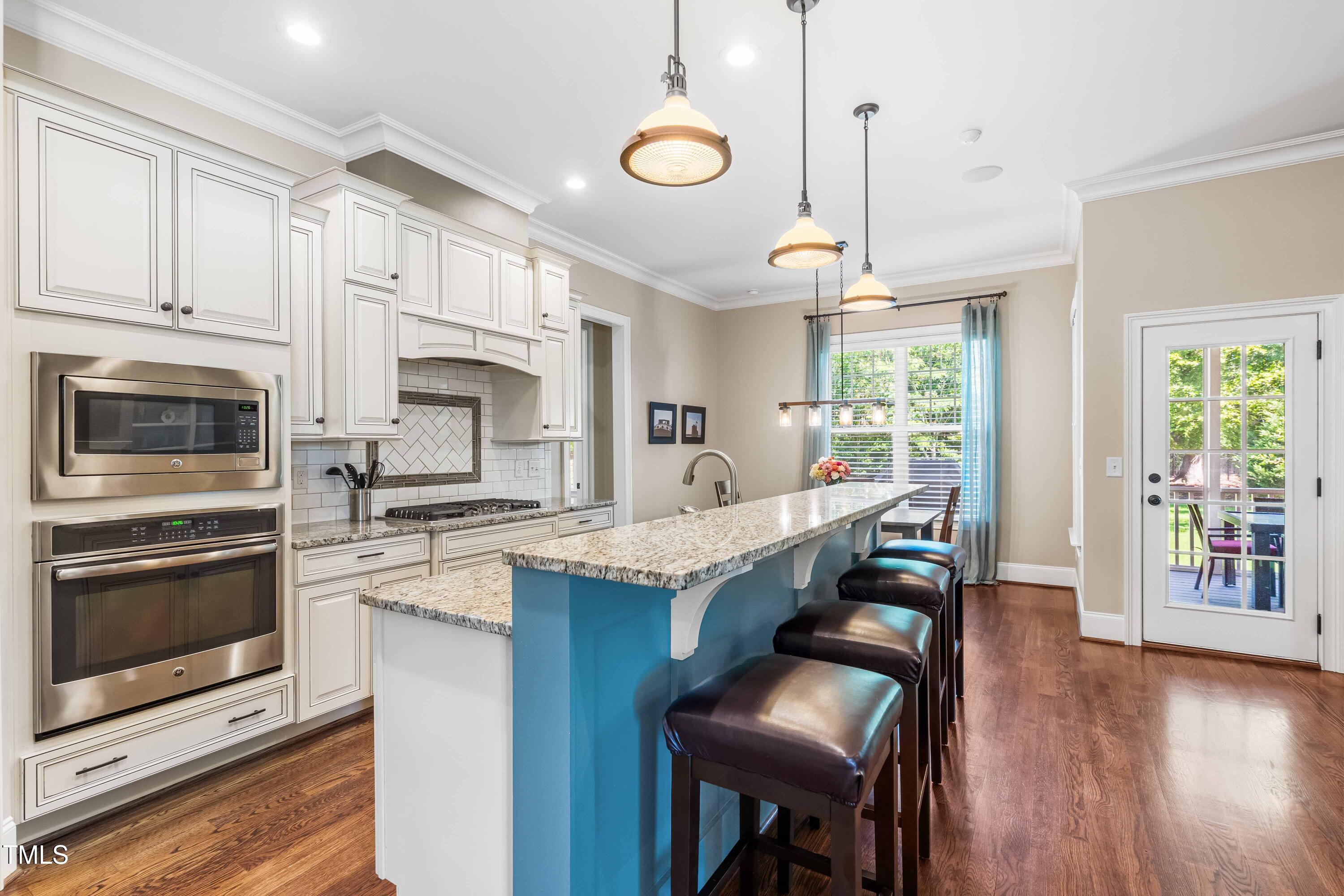 2538 Tuffeto Apex, NC 27502 - Photo 14 of 55 a kitchen with granite countertop counter space a stove a sink a dining table and chairs