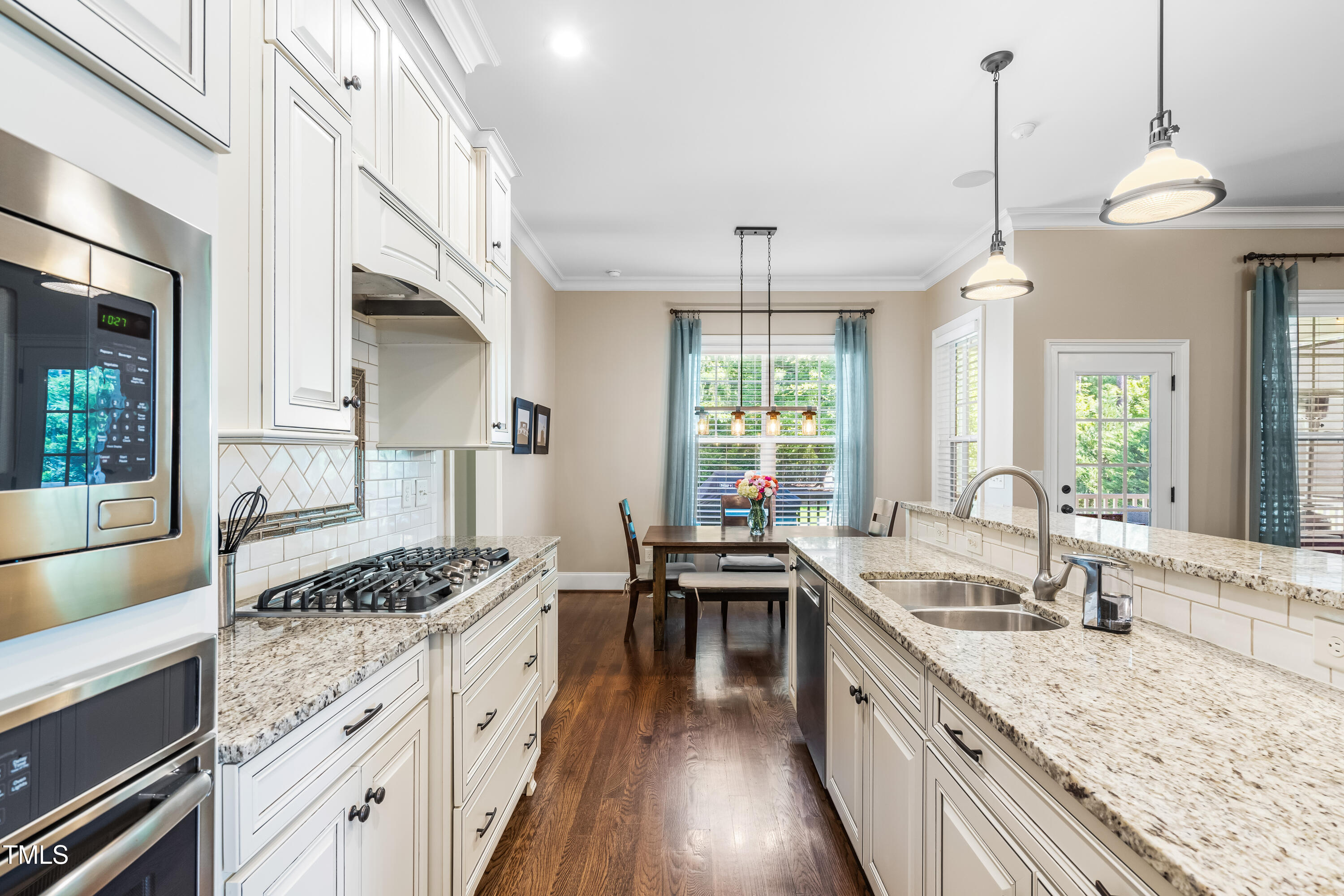 2538 Tuffeto Apex, NC 27502 - Photo 19 of 55 a kitchen with granite countertop a stove a sink a dining table and chairs