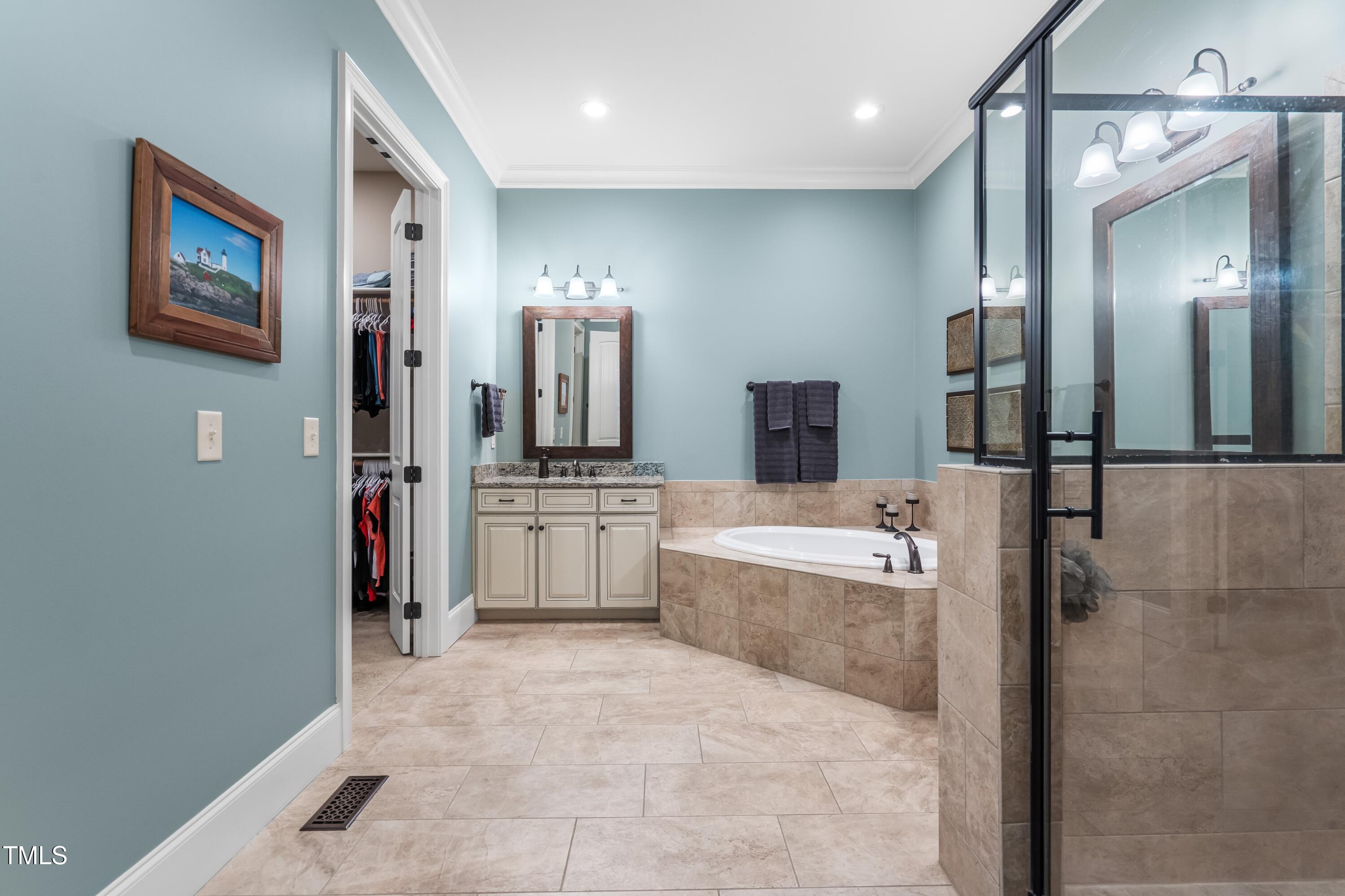 2538 Tuffeto Apex, NC 27502 - Photo 32 of 55 a bathroom with a tub sink and mirror
