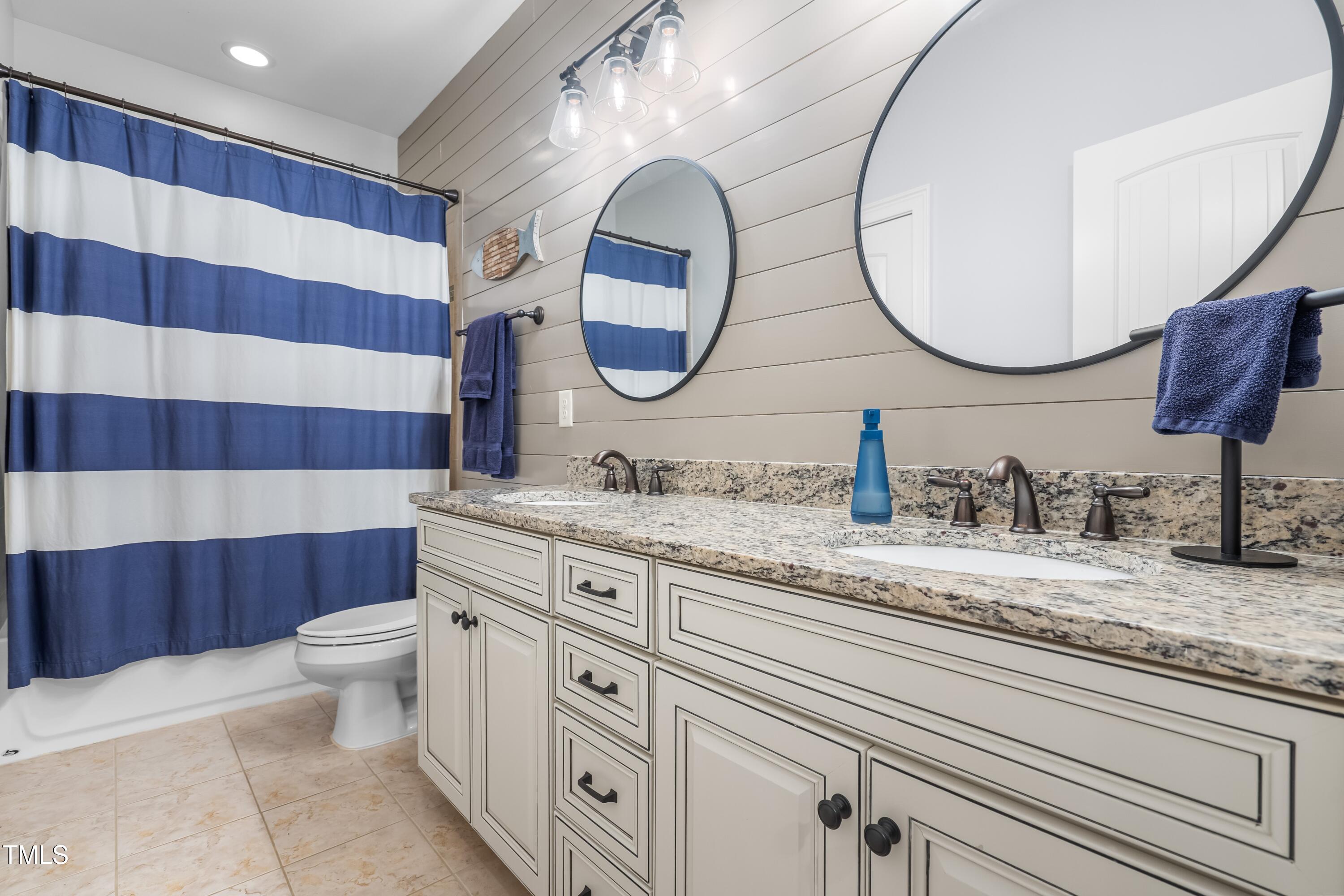 2538 Tuffeto Apex, NC 27502 - Photo 37 of 55 a bathroom with a granite countertop toilet a sink and a mirror