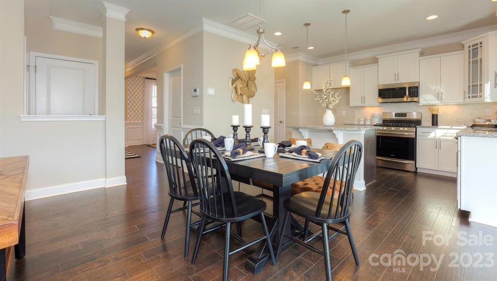 679 Fox Cove Road Hendersonville, NC 28792 - Photo 12 of 35 a dining room with stainless steel appliances kitchen island granite countertop a table chairs and a refrigerator
