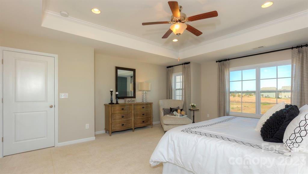 679 Fox Cove Road Hendersonville, NC 28792 - Photo 23 of 35 a large bedroom with a bed a chandelier and a large window