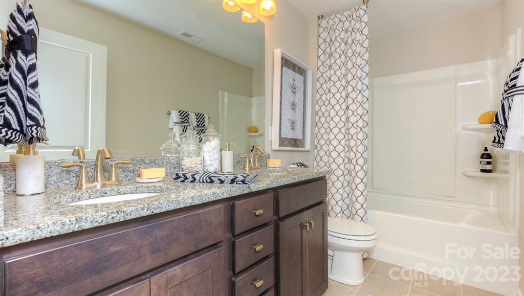 679 Fox Cove Road Hendersonville, NC 28792 - Photo 33 of 35 a bathroom with a granite countertop sink mirror vanity and toilet