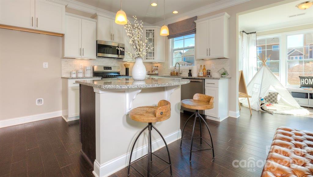 679 Fox Cove Road Hendersonville, NC 28792 - Photo 7 of 35 a kitchen with stainless steel appliances granite countertop a stove top oven a sink a refrigerator white cabinets and wooden floor