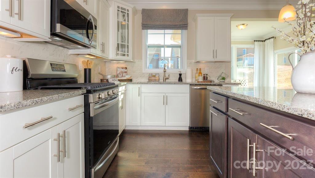 679 Fox Cove Road Hendersonville, NC 28792 - Photo 10 of 35 a kitchen with stainless steel appliances granite countertop a sink and stove top oven