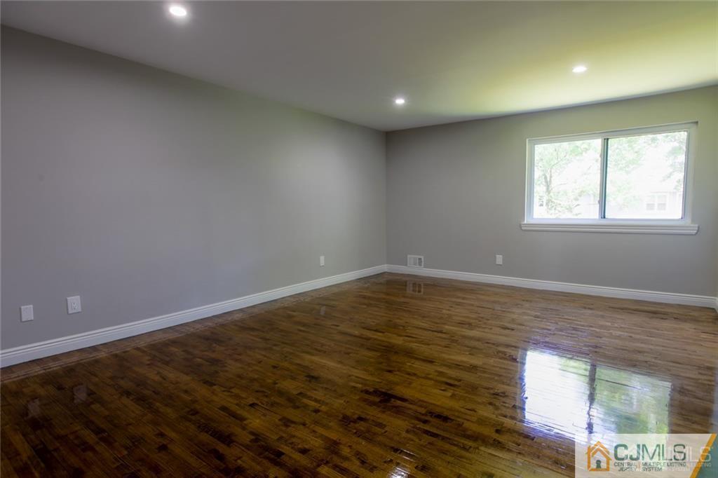 4103 Hana Road Edison, NJ 08817 - Photo 8 of 16 an empty room with wooden floor and windows