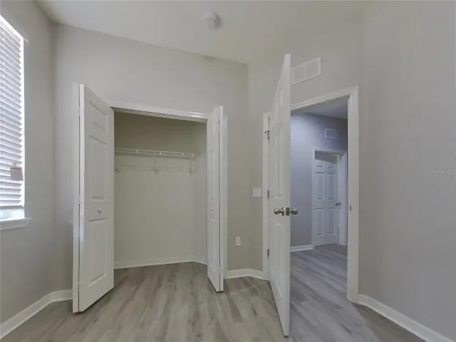 an empty room with closet and wooden floor