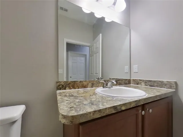 a bathroom with a granite countertop sink and a mirror