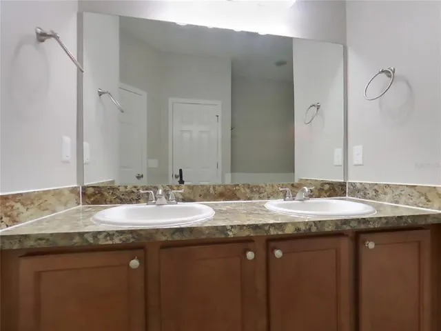 a bathroom with a granite countertop sink and a mirror