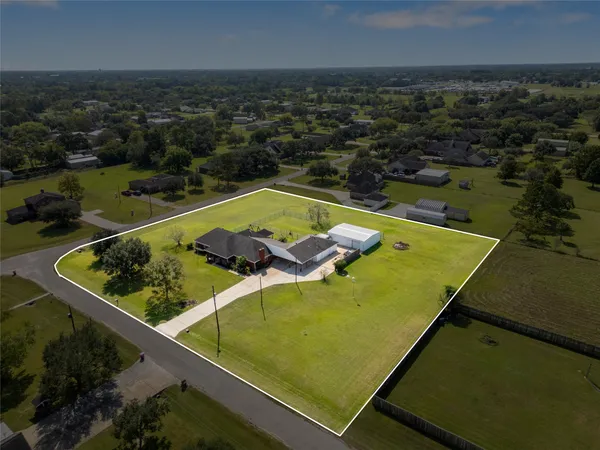 an aerial view of a residential houses with outdoor space and lake view