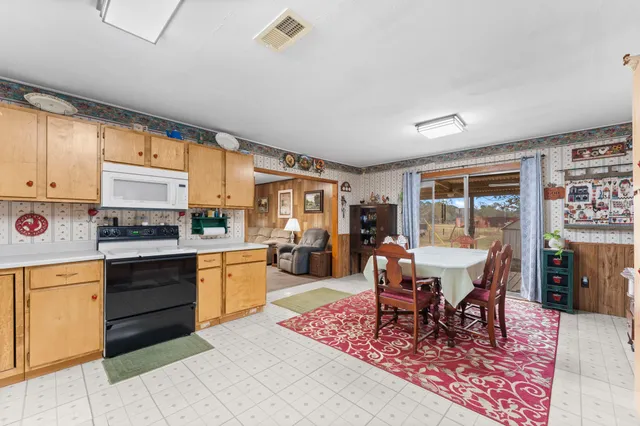 a kitchen with a dining table and chairs with wooden floor