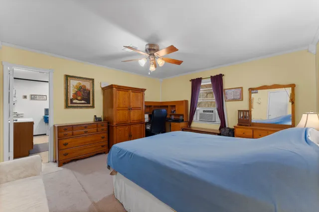a spacious bedroom with a large bed and a chandelier