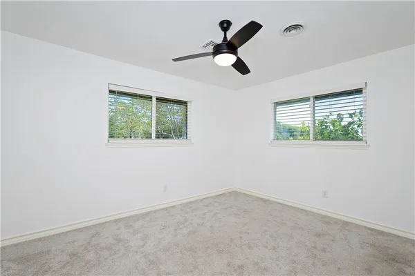 an empty room with a window and a fan