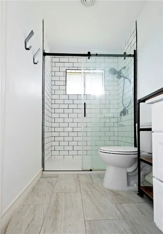 a bathroom with a toilet and a shower