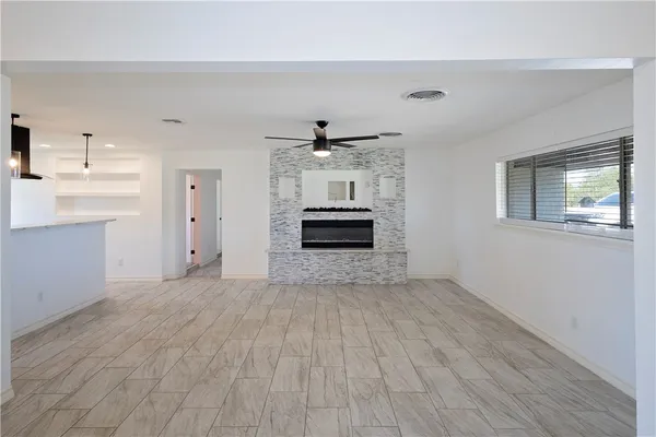 a view of empty room with wooden floor and windows