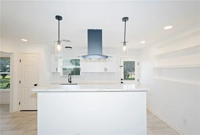 a kitchen with kitchen island stainless steel appliances a sink and cabinets
