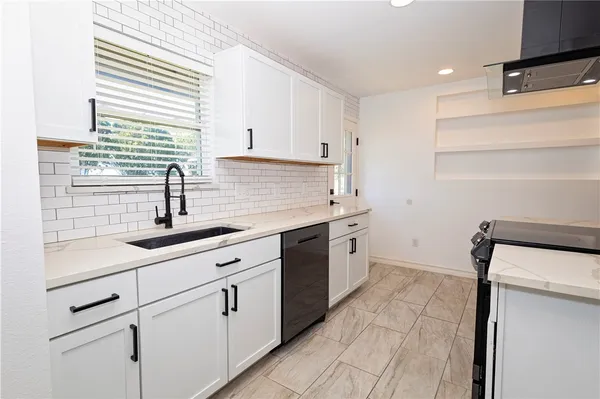 a kitchen with a sink cabinets and window