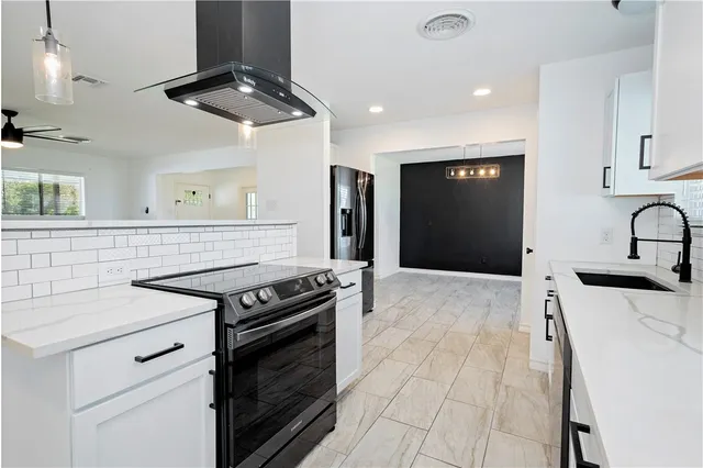 a kitchen with stainless steel appliances a stove a sink and a refrigerator