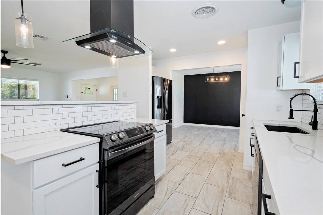7629 Lang Road Portland, TX 78374 - Photo 9 of 36 a kitchen with stainless steel appliances a stove a sink and a refrigerator