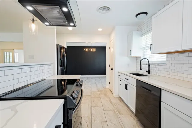 a kitchen with a sink a counter top space cabinets and stainless steel appliances