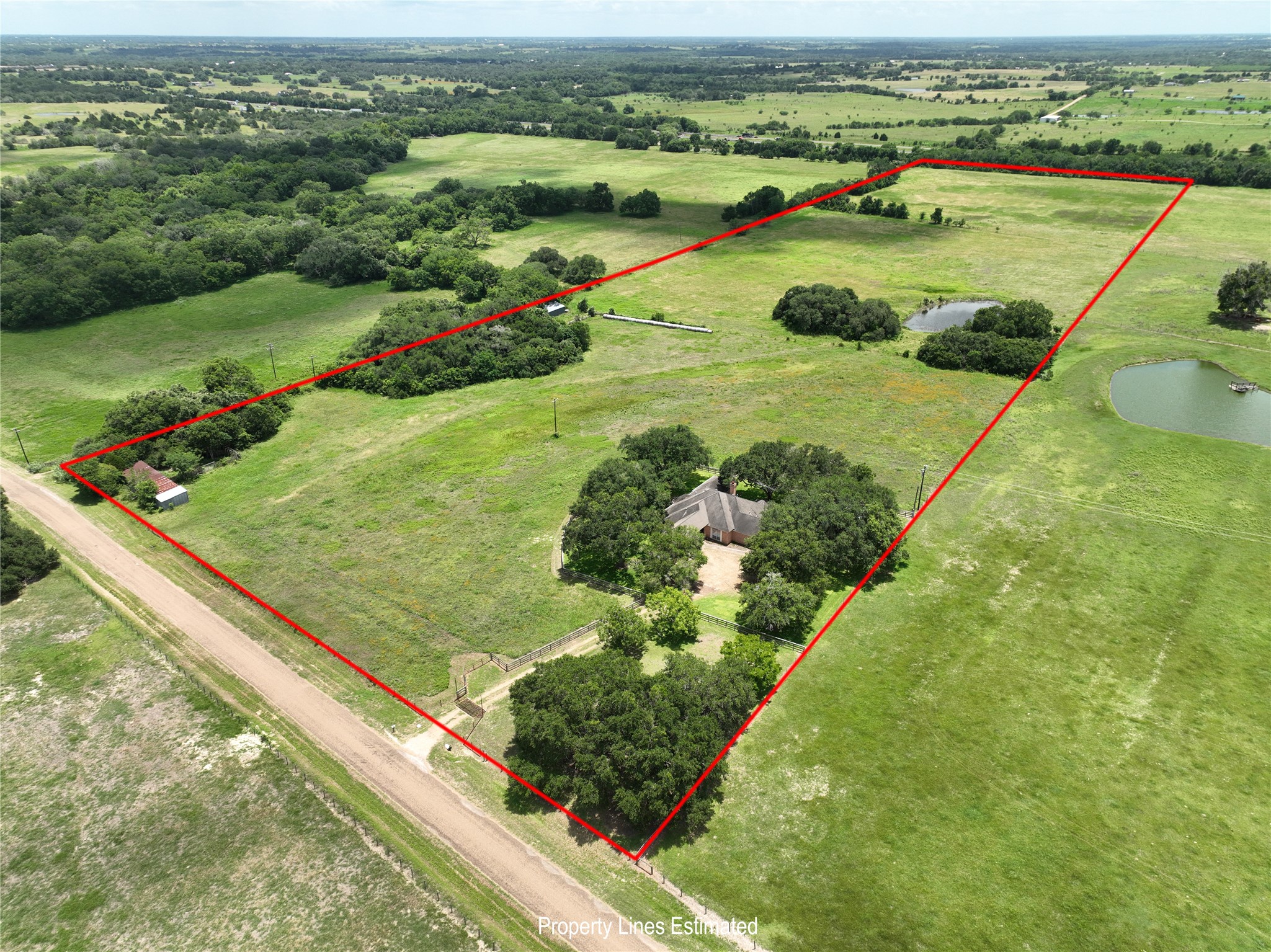 1552 Holub Road Schulenburg, TX 78956 - Photo 1 of 45 View from the northwest corner shows the expansive land including pastures, trees, and a small pond, offering privacy and scenic views, ideal for those seeking a tranquil country lifestyle. With the home on the right side of the property, this can be subdivided into smaller acreage.