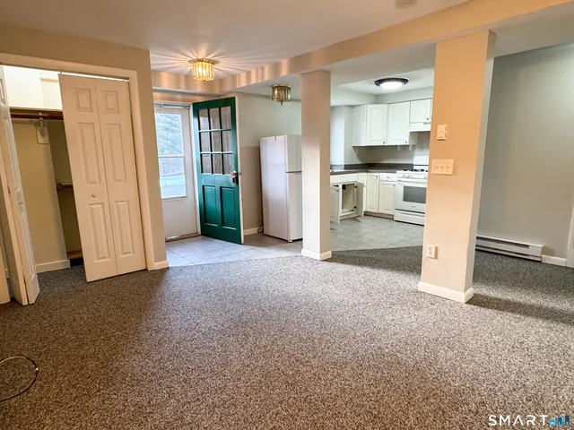 a view of empty room with a kitchen