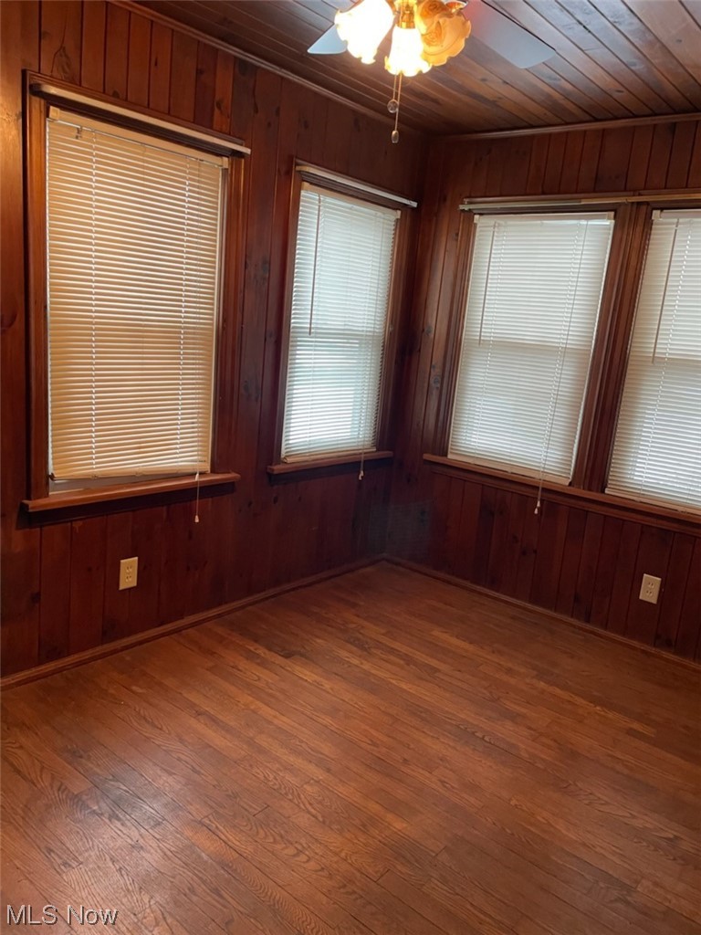 4204 Kirk Road Youngstown, OH 44511 - Photo 2 of 2 Unfurnished room featuring dark hardwood / wood-style floors, ceiling fan, wooden ceiling, and wooden walls