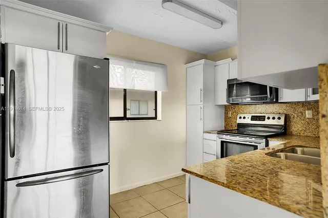 a kitchen with stainless steel appliances granite countertop a refrigerator and a sink