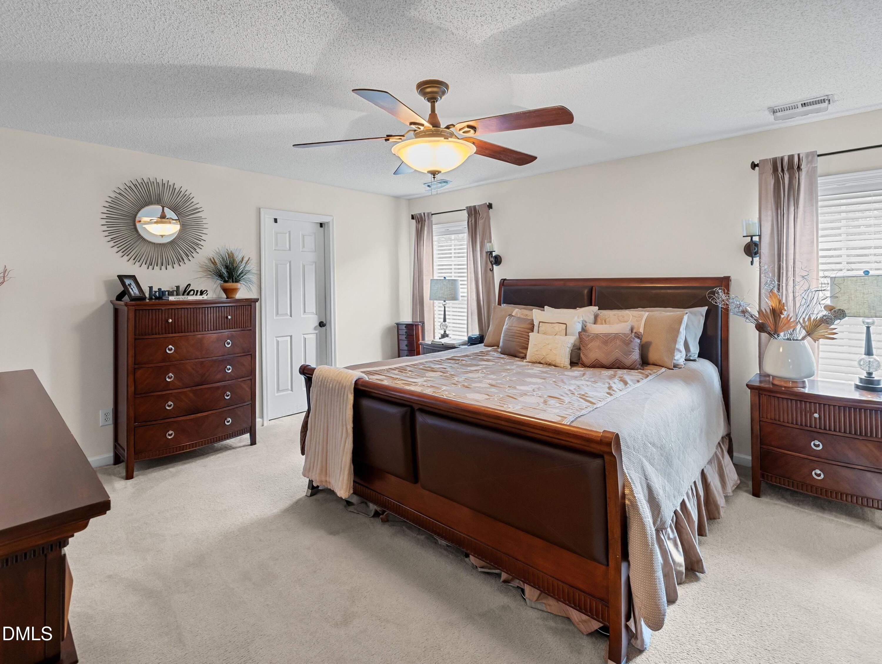 8911 Elizabeth Bennet Place Raleigh, NC 27616 - Photo 10 of 25 a bedroom with a bed and a chandelier