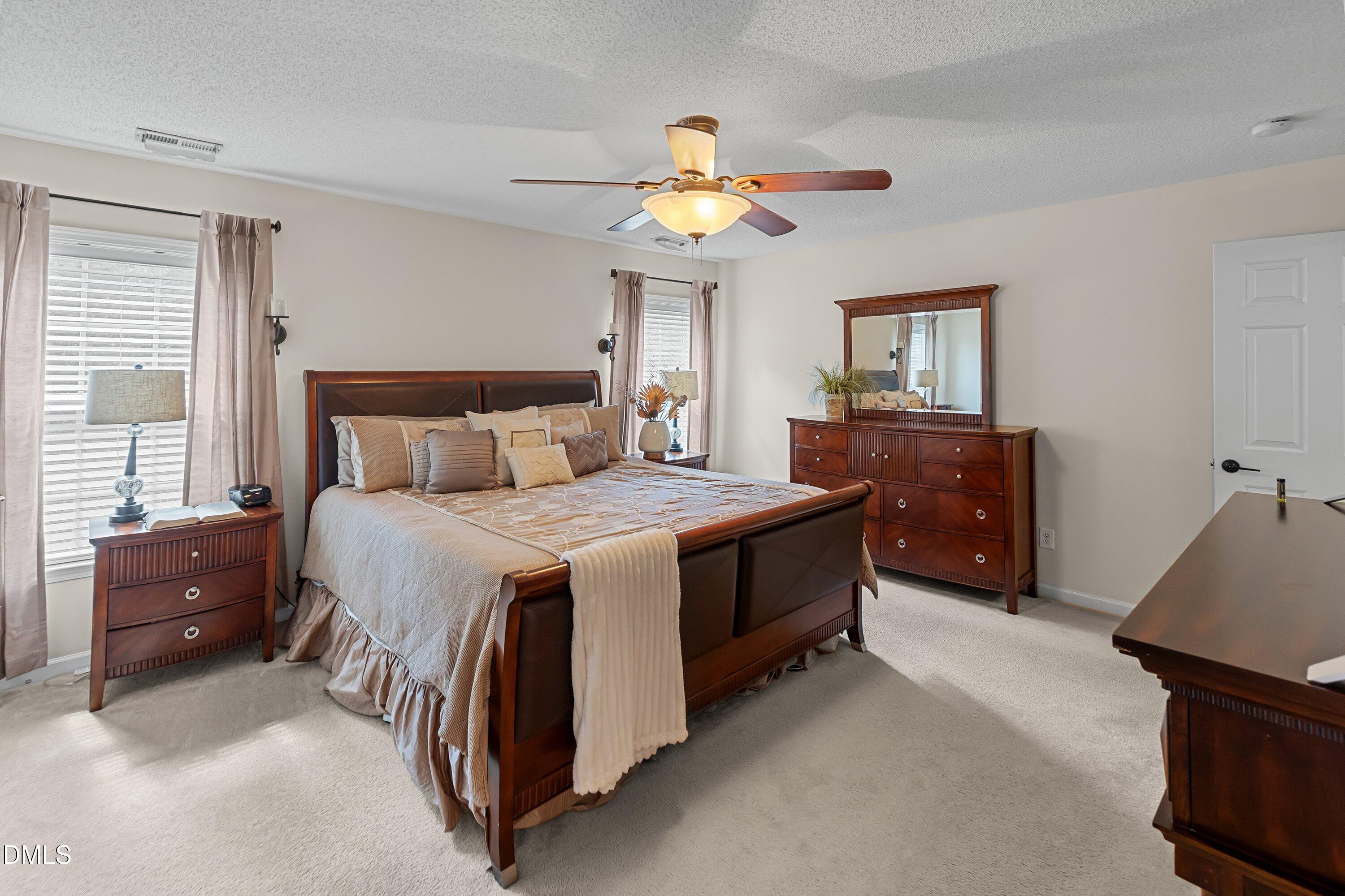 8911 Elizabeth Bennet Place Raleigh, NC 27616 - Photo 11 of 25 a bedroom with a bed and a chandelier