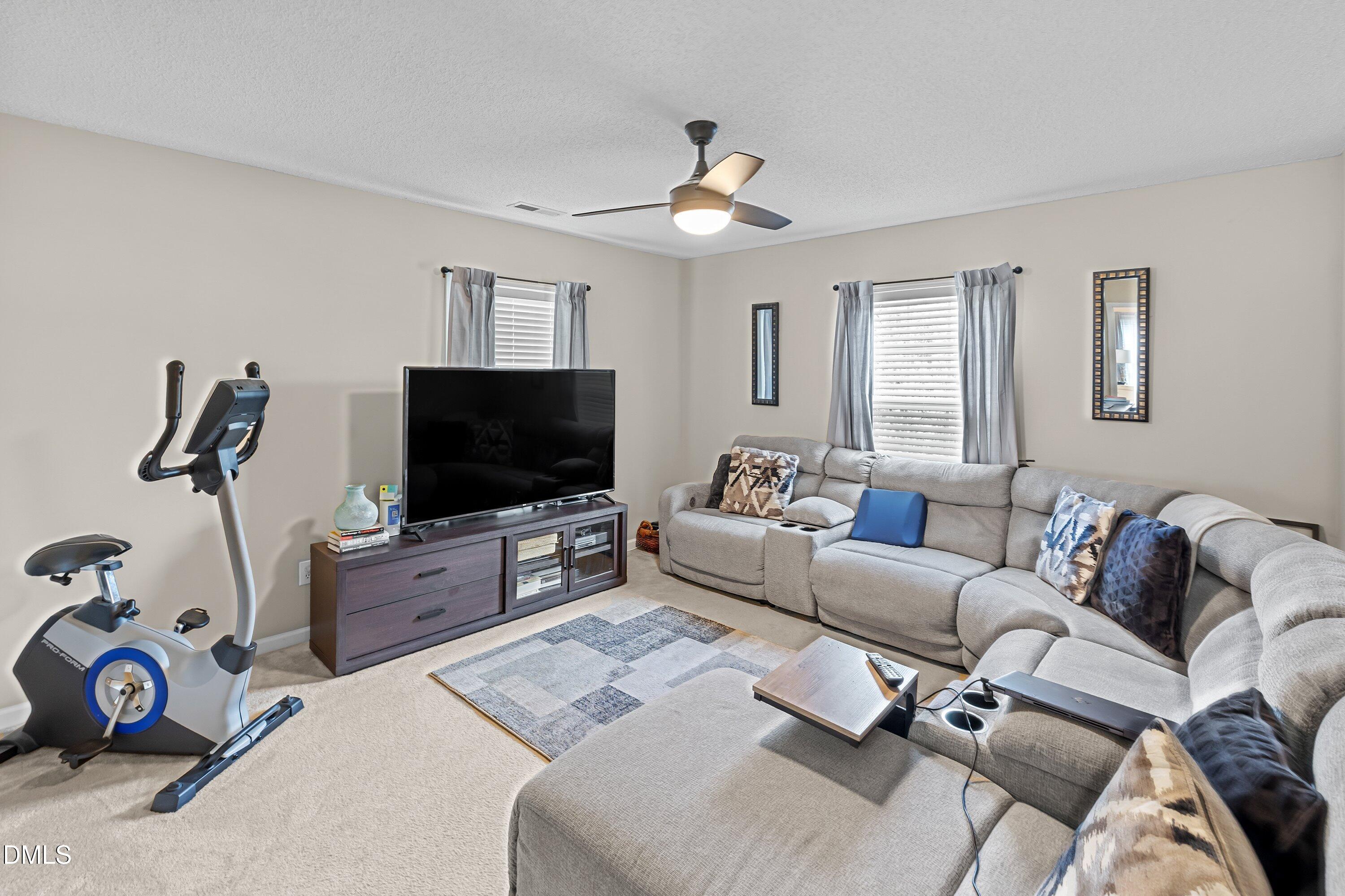 8911 Elizabeth Benneth Place Raleigh, NC 27616 - Photo 13 of 31 a living room with furniture and a flat screen tv