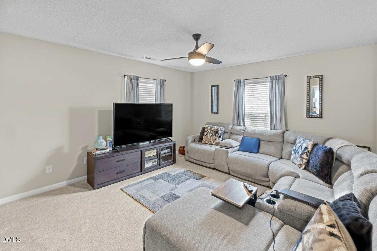 8911 Elizabeth Bennet Place Raleigh, NC 27616 - Photo 14 of 25 a living room with furniture and a flat screen tv