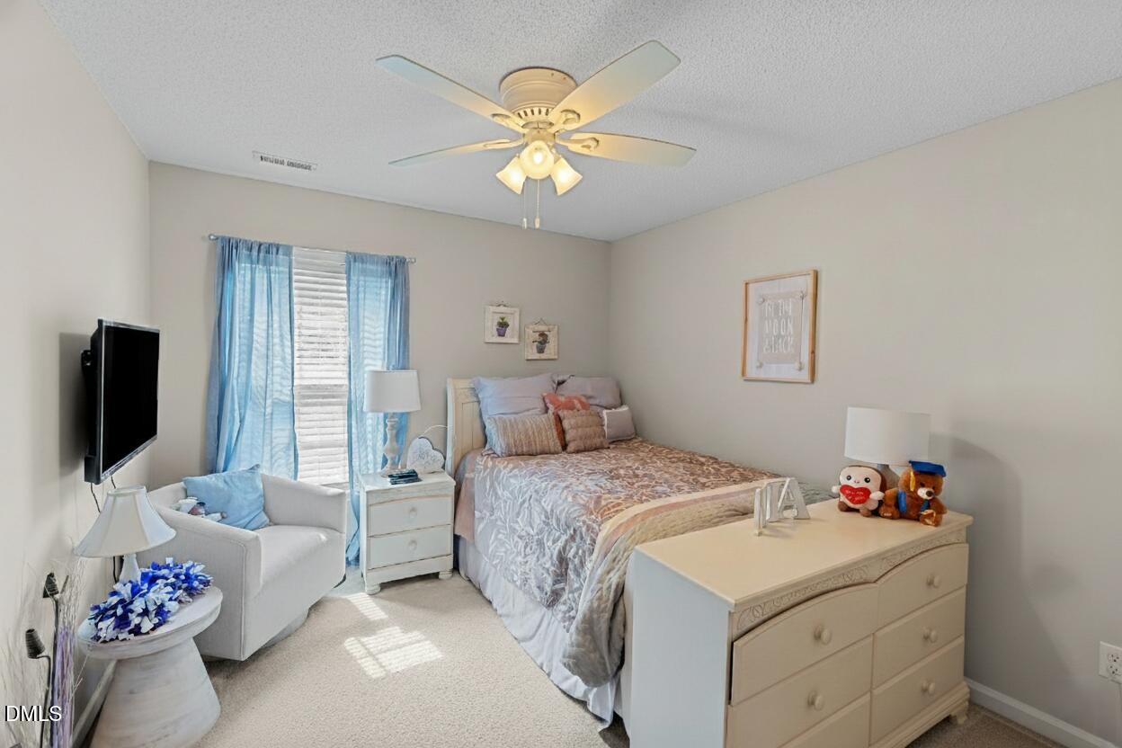 8911 Elizabeth Bennet Place Raleigh, NC 27616 - Photo 15 of 25 a bedroom with a bed and a flat screen tv