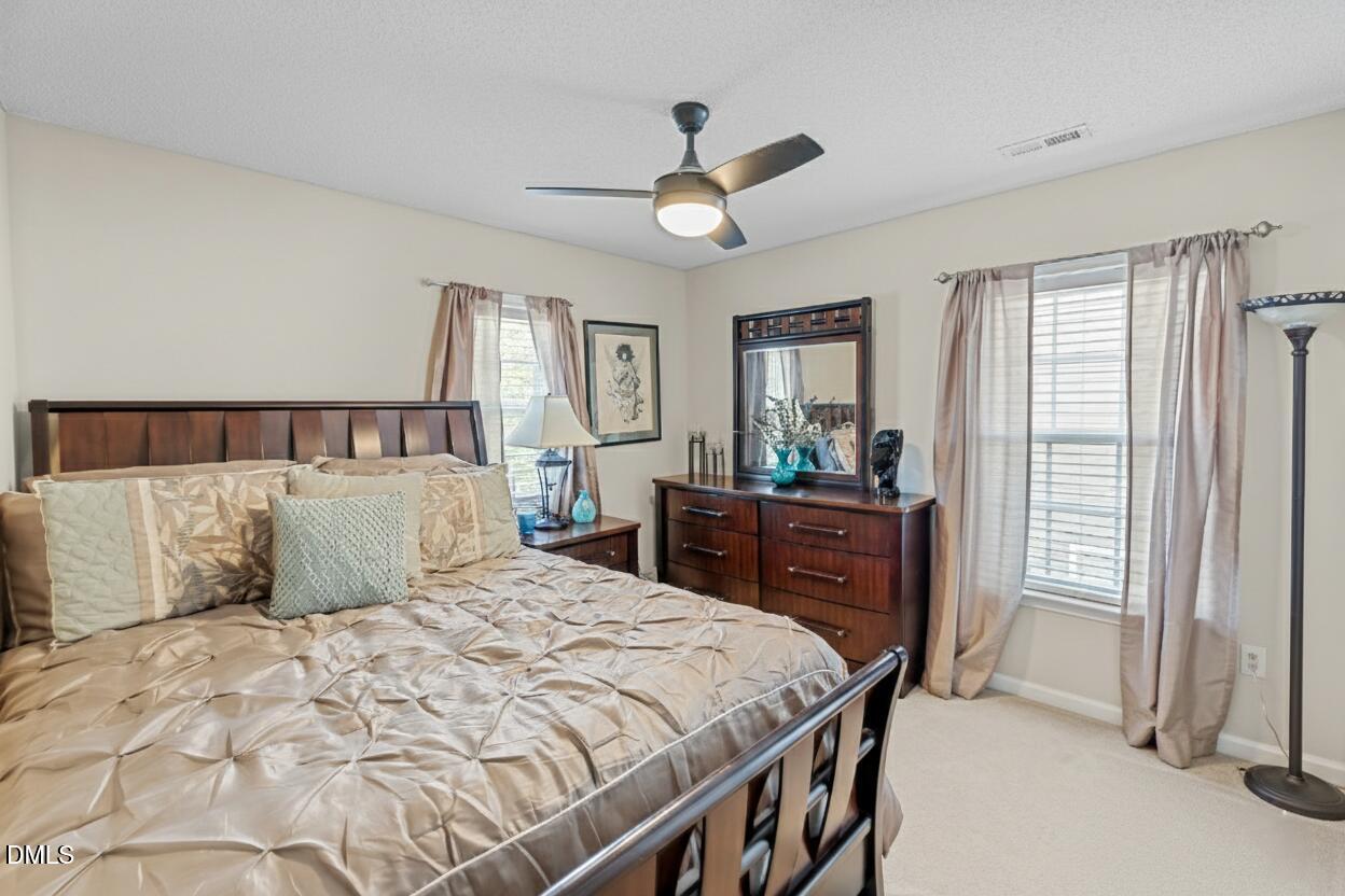 8911 Elizabeth Bennet Place Raleigh, NC 27616 - Photo 16 of 25 a bedroom with a bed and wooden floor